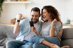 een stel ziet op hun mobiel dat ze de euromillions jackpot hebben gewonnen en zijn blij